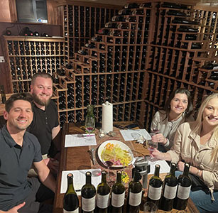 Guests around a cellar table with bottles of Aum Cellars wine